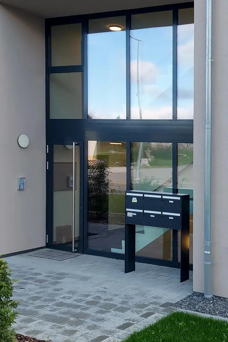 Porte d'entrée métallique et verrières d'un immeuble.
