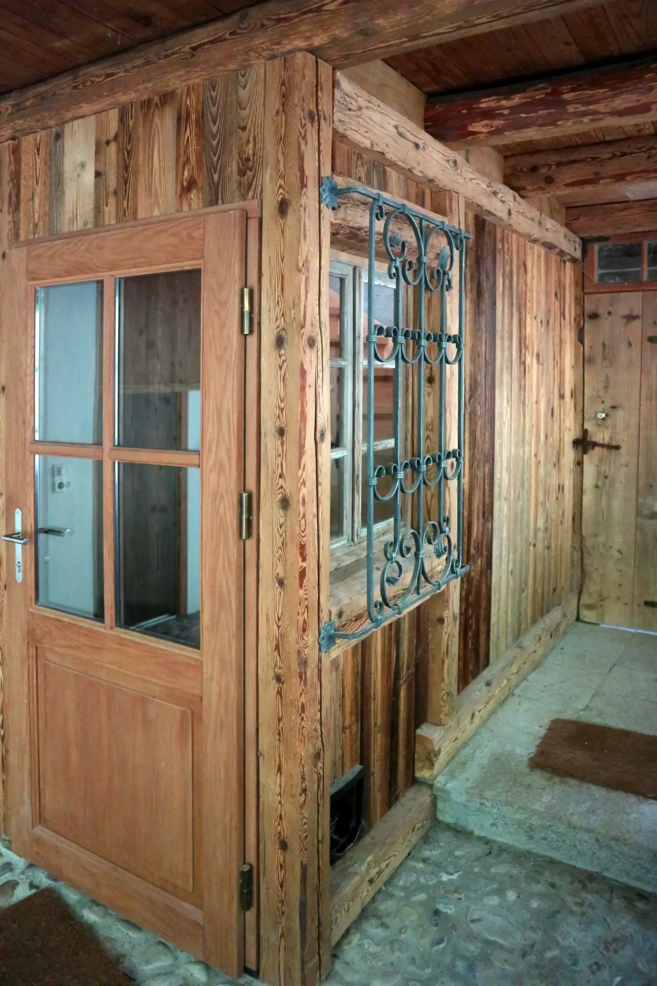 Porte extérieurs et fenêtre en bois sur une façade rustique.